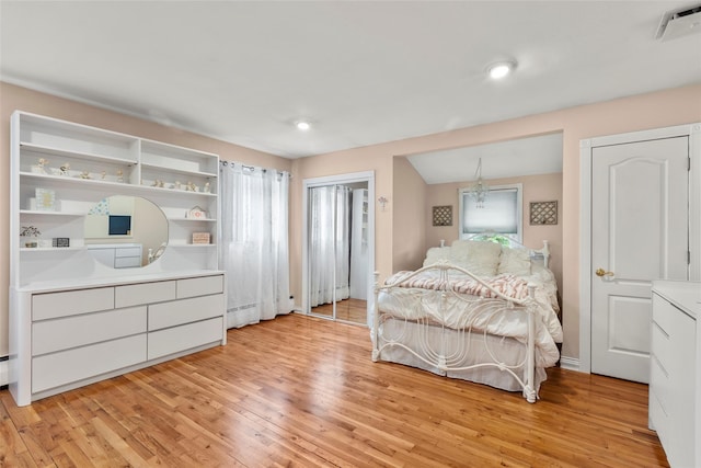 8 Wichard Blvd, Commack, NY 11725 - bedroom with light wood-style floors, a baseboard heating unit, and a chandelier