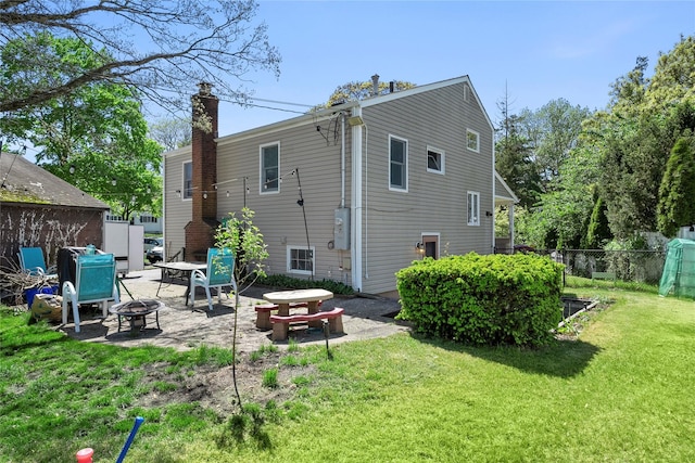 31 Wagon Ln E, Centereach, NY 11720 - back of property featuring an outdoor fire pit, a patio, and a chimney