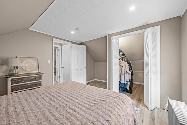 14 Mercer St, Middletown, NY 10940 - bedroom featuring radiator, wood finished floors, vaulted ceiling, a spacious closet, and baseboards