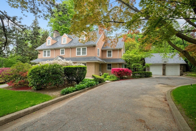 681 W 231st St, Bronx, NY 10463 - view of front of house featuring a chimney, asphalt driveway, and stucco siding