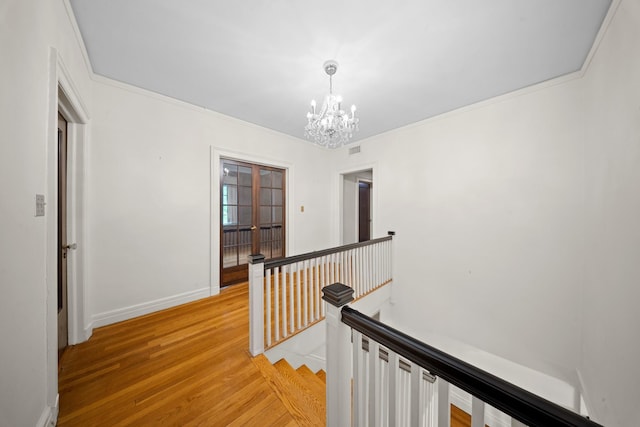 681 W 231st St, Bronx, NY 10463 - corridor with an upstairs landing, a chandelier, light wood-style flooring, baseboards, and ornamental molding
