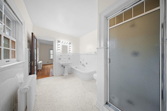 681 W 231st St, Bronx, NY 10463 - full bathroom with radiator heating unit, a stall shower, tile walls, a freestanding tub, and wainscoting