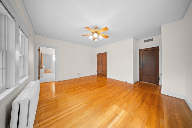 681 W 231st St, Bronx, NY 10463 - spare room with radiator, a ceiling fan, light wood-style flooring, and baseboards
