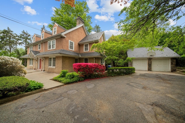 681 W 231st St, Bronx, NY 10463 - view of front of house featuring a chimney, stucco siding, and a detached garage