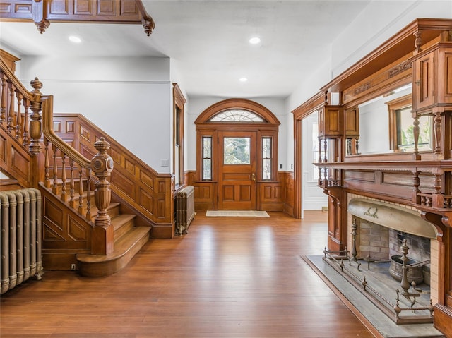 30 Huntting Ln, East Hampton, NY 11937 - foyer entrance with radiator, stairs, hardwood / wood-style flooring, wainscoting, and a decorative wall