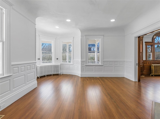 30 Huntting Ln, East Hampton, NY 11937 - unfurnished room with radiator heating unit, healthy amount of natural light, a wainscoted wall, a decorative wall, and recessed lighting