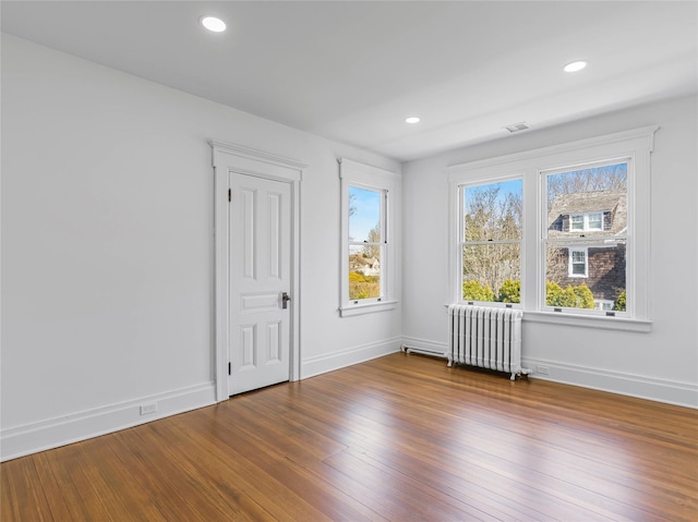30 Huntting Ln, East Hampton, NY 11937 - empty room featuring radiator heating unit, wood finished floors, baseboards, and recessed lighting