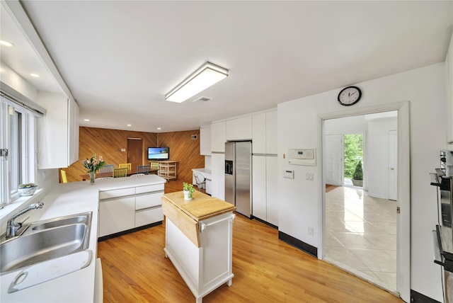 4 Bobby Close, Mamaroneck, NY 10543 - kitchen with stainless steel refrigerator with ice dispenser, a sink, white cabinetry, light countertops, and wood walls