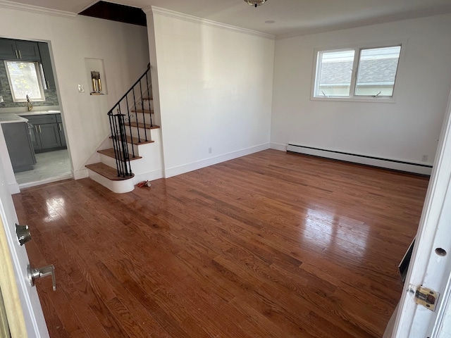 1963 Central Dr N, East Meadow, NY 11554 - unfurnished room with a baseboard radiator, crown molding, wood finished floors, stairway, and a sink