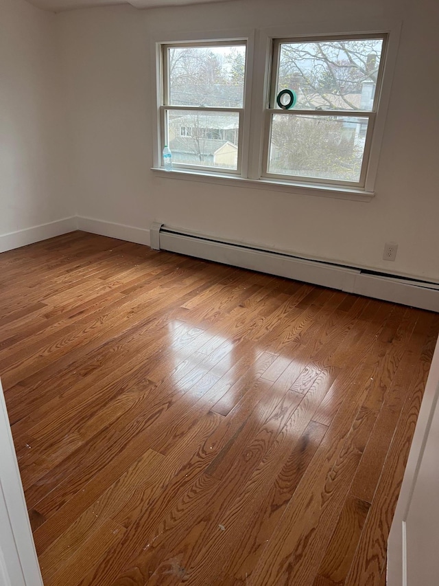 1963 Central Dr N, East Meadow, NY 11554 - empty room featuring a baseboard radiator, light wood-style floors, and baseboards