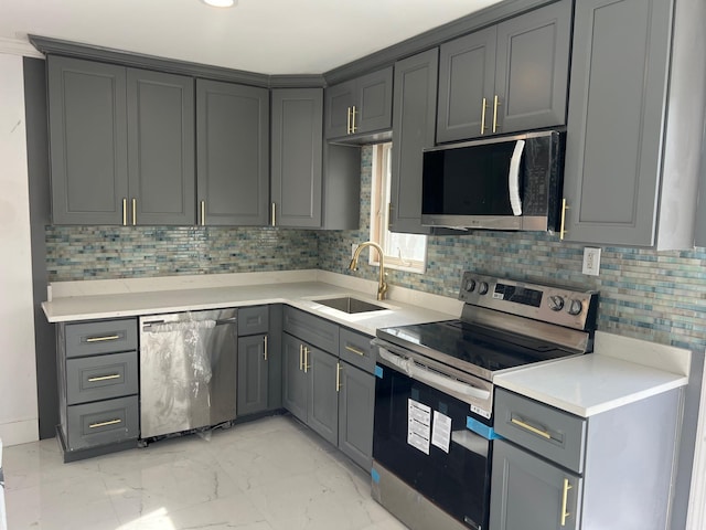 1963 Central Dr N, East Meadow, NY 11554 - kitchen featuring appliances with stainless steel finishes, a sink, gray cabinetry, and tasteful backsplash