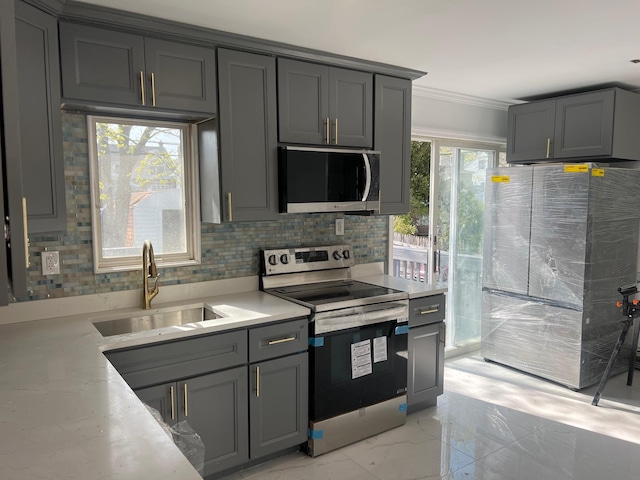 1963 Central Dr N, East Meadow, NY 11554 - kitchen with appliances with stainless steel finishes, a sink, gray cabinetry, backsplash, and crown molding
