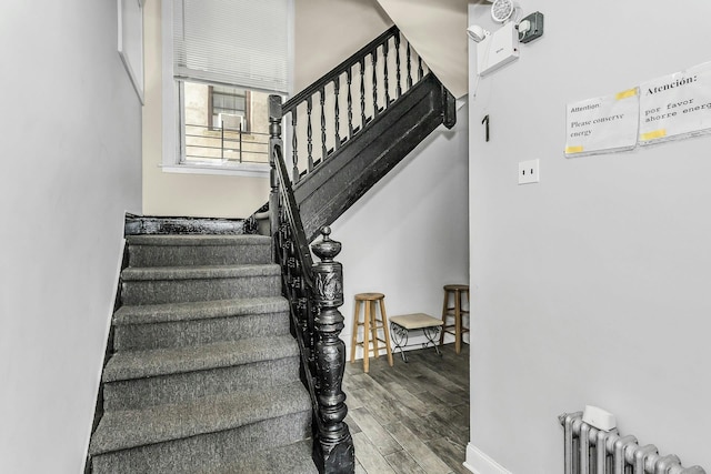 34-21 9th St, Astoria, NY 11106 - staircase with radiator heating unit, wood finished floors, and baseboards