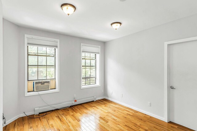 34-21 9th St, Astoria, NY 11106 - spare room featuring baseboard heating, light wood-type flooring, baseboards, and cooling unit