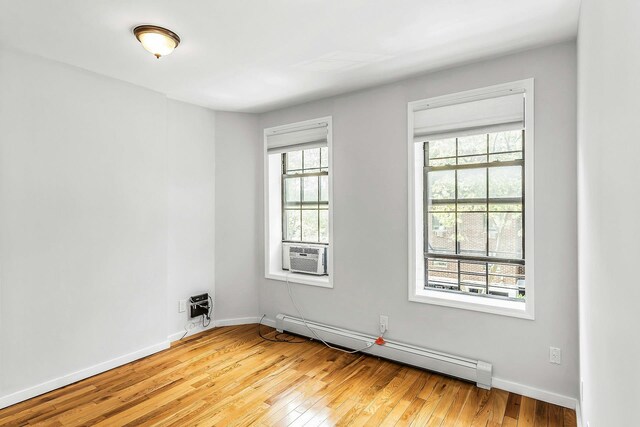 34-21 9th St, Astoria, NY 11106 - empty room featuring baseboard heating, light wood finished floors, baseboards, and cooling unit