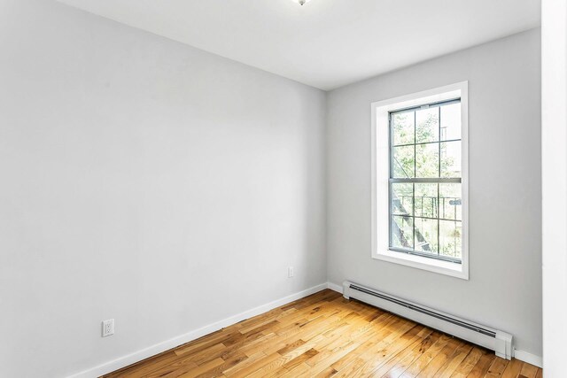34-21 9th St, Astoria, NY 11106 - unfurnished room with baseboard heating, light wood-style floors, and baseboards