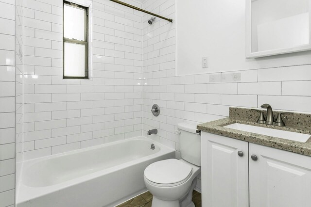 34-21 9th St, Astoria, NY 11106 - full bath with tile walls, toilet, vanity, and washtub / shower combination