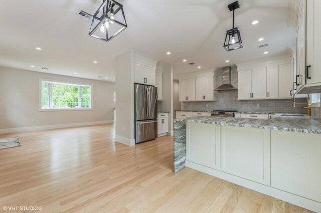 6 Reina Ct, Valley Cottage, NY 10989 - kitchen featuring stainless steel appliances, wall chimney range hood, backsplash, light wood finished floors, and light stone counters