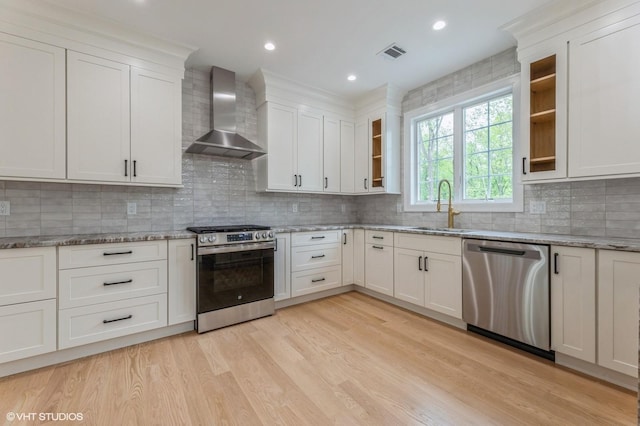 6 Reina Ct, Valley Cottage, NY 10989 - kitchen featuring appliances with stainless steel finishes, wall chimney range hood, a sink, light wood finished floors, and glass insert cabinets