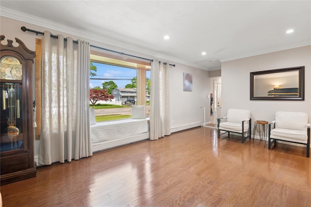 979 Manor Ln, Bay Shore, NY 11706 - living area with ornamental molding, wood finished floors, recessed lighting, baseboards, and baseboard heating