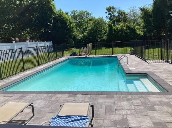 979 Manor Ln, Bay Shore, NY 11706 - view of pool featuring a patio area and view of wooded area