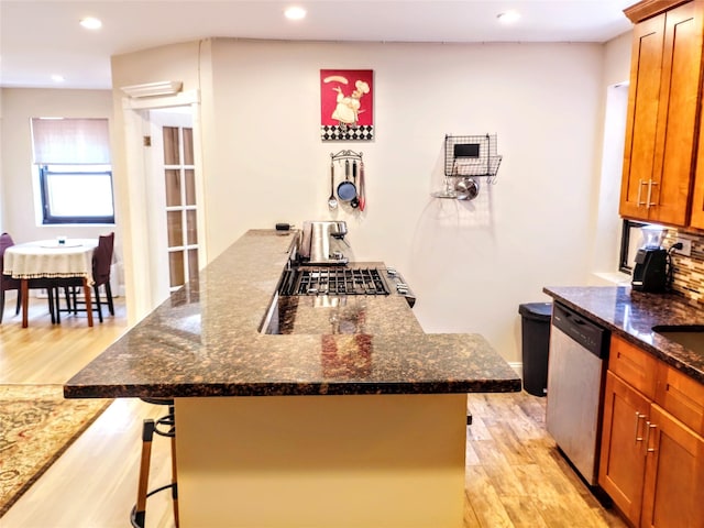 118-60 Metropolitan Ave Unit 6F, Kew Gardens, NY 11415 - kitchen with dishwasher, light wood-style floors, a breakfast bar, a peninsula, and brown cabinets