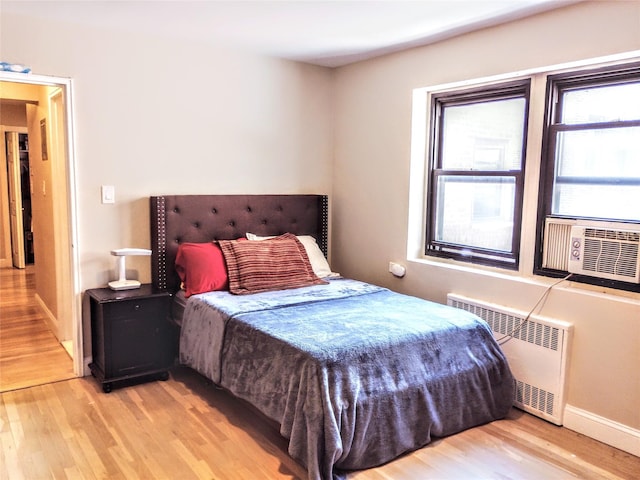 118-60 Metropolitan Ave Unit 6F, Kew Gardens, NY 11415 - bedroom with radiator heating unit, light wood-style flooring, cooling unit, and baseboards