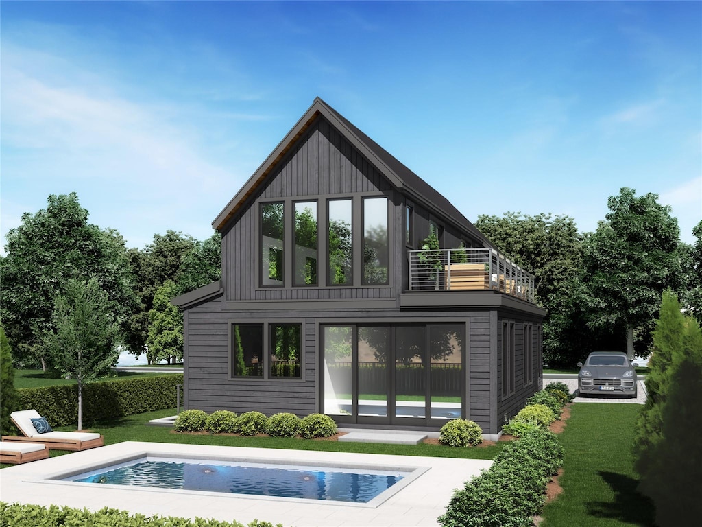 back of property featuring a balcony, a lawn, and an outdoor pool