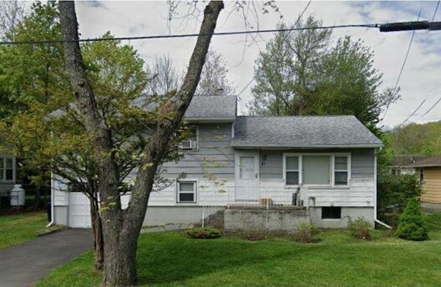 21 Hammond St, Monticello, NY 12701 - view of front facade with a front lawn, a garage, a shingled roof, and driveway