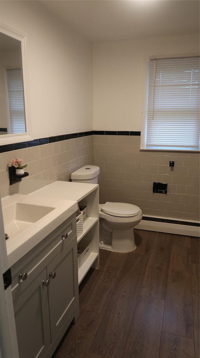 21 Hammond St, Monticello, NY 12701 - half bath with tile walls, toilet, wood finished floors, vanity, and a wainscoted wall