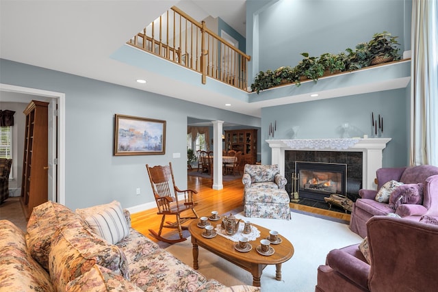11 Jodi Dr, Newburgh, NY 12550 - living room featuring ornate columns, a tiled fireplace, wood finished floors, a high ceiling, and baseboards