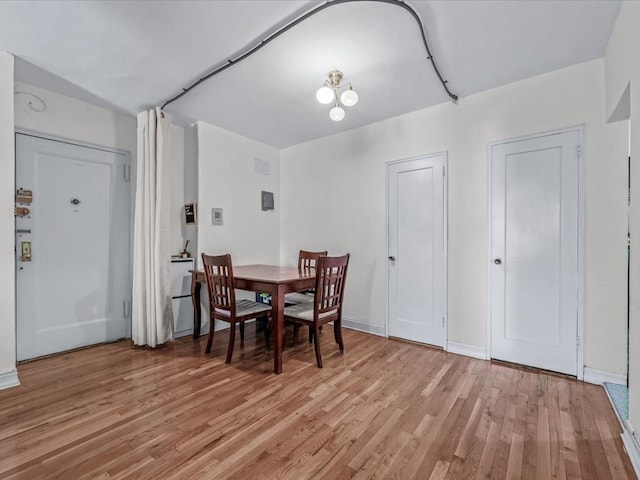 dining room with light wood-type flooring and baseboards