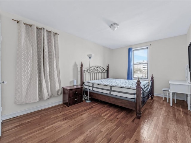bedroom featuring wood finished floors and baseboards