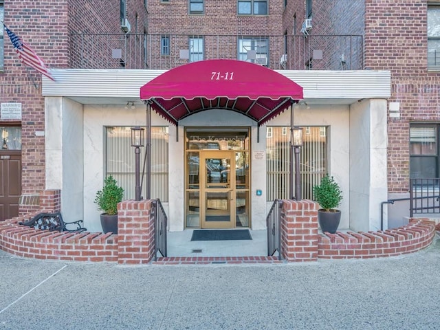 property entrance with brick siding and stucco siding