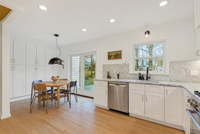 kitchen featuring stainless steel appliances, a sink, light wood finished floors, white cabinets, and recessed lighting