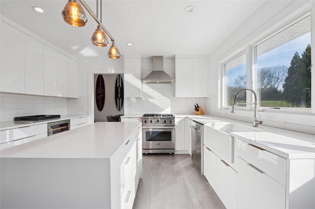 kitchen featuring wall chimney exhaust hood, stainless steel appliances, modern cabinets, and recessed lighting
