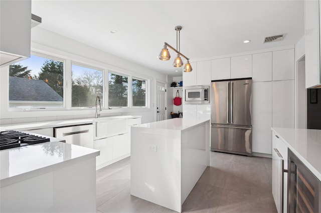 kitchen featuring stainless steel appliances, modern cabinets, white cabinets, wine cooler, and recessed lighting