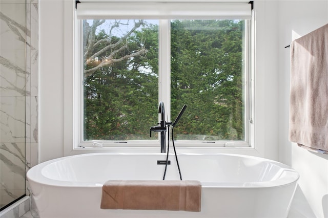 bathroom with a freestanding tub and a sink
