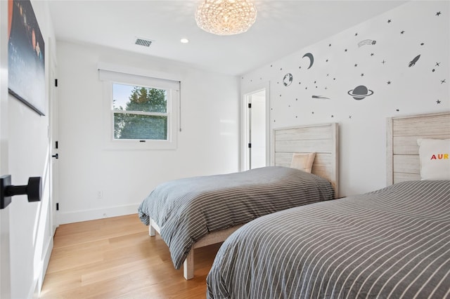bedroom with light wood-type flooring and baseboards
