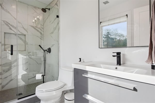 full bath featuring toilet, vanity, and a marble finish shower