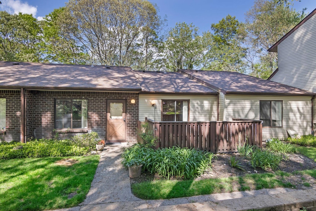 115 Birchwood Rd, Coram, NY 11727 - view of front of house with a deck, brick siding, and a shingled roof