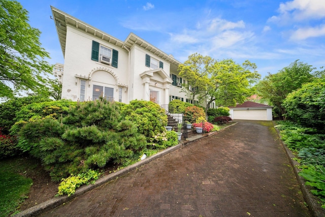 10-08 Shore Rd, Douglaston, NY 11363 - view of front of home featuring a detached garage, an outbuilding, and stucco siding