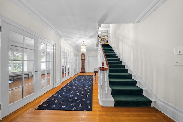 10-08 Shore Rd, Douglaston, NY 11363 - stairway featuring crown molding, wood finished floors, a chandelier, and french doors