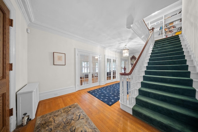 10-08 Shore Rd, Douglaston, NY 11363 - entrance foyer featuring french doors, stairs, crown molding, wood finished floors, and a chandelier