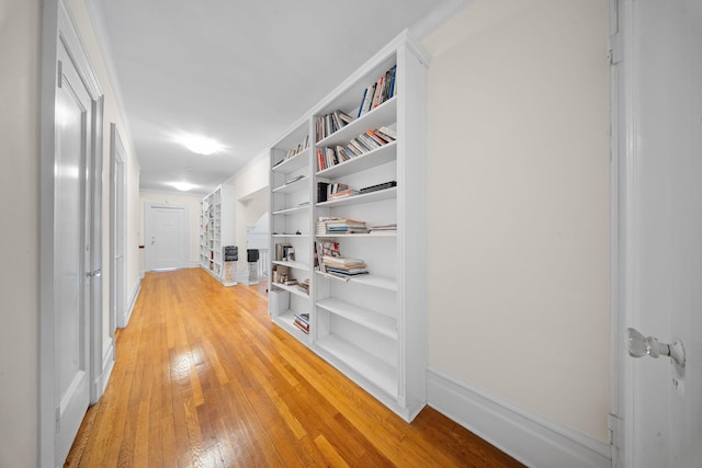 10-08 Shore Rd, Douglaston, NY 11363 - hallway with light wood finished floors, baseboards, and built in shelves
