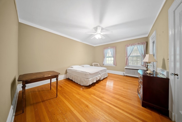 10-08 Shore Rd, Douglaston, NY 11363 - bedroom with radiator, light wood-type flooring, baseboards, ornamental molding, and a ceiling fan