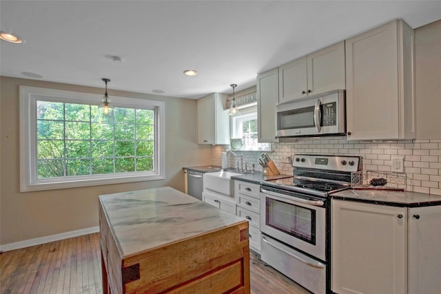 59 E Main St, Washingtonville, NY 10992 - kitchen featuring stainless steel appliances, a sink, baseboards, backsplash, and light wood finished floors