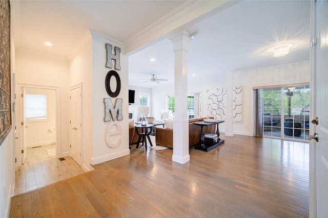 hall with wood finished floors, healthy amount of natural light, crown molding, baseboards, and recessed lighting