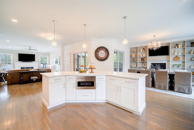 kitchen featuring a glass covered fireplace, open floor plan, ceiling fan, a chandelier, and recessed lighting