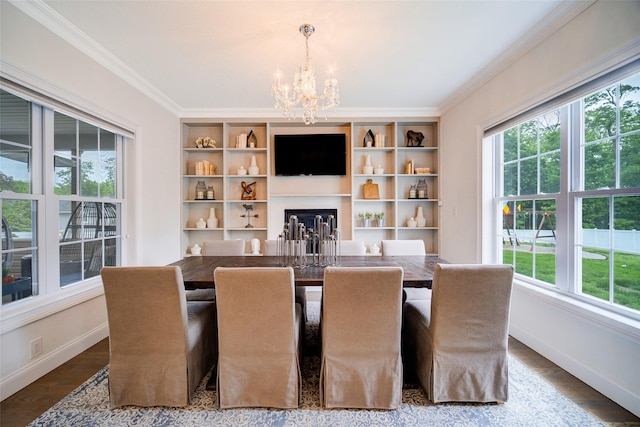 dining room featuring healthy amount of natural light, a chandelier, ornamental molding, baseboards, and wood finished floors